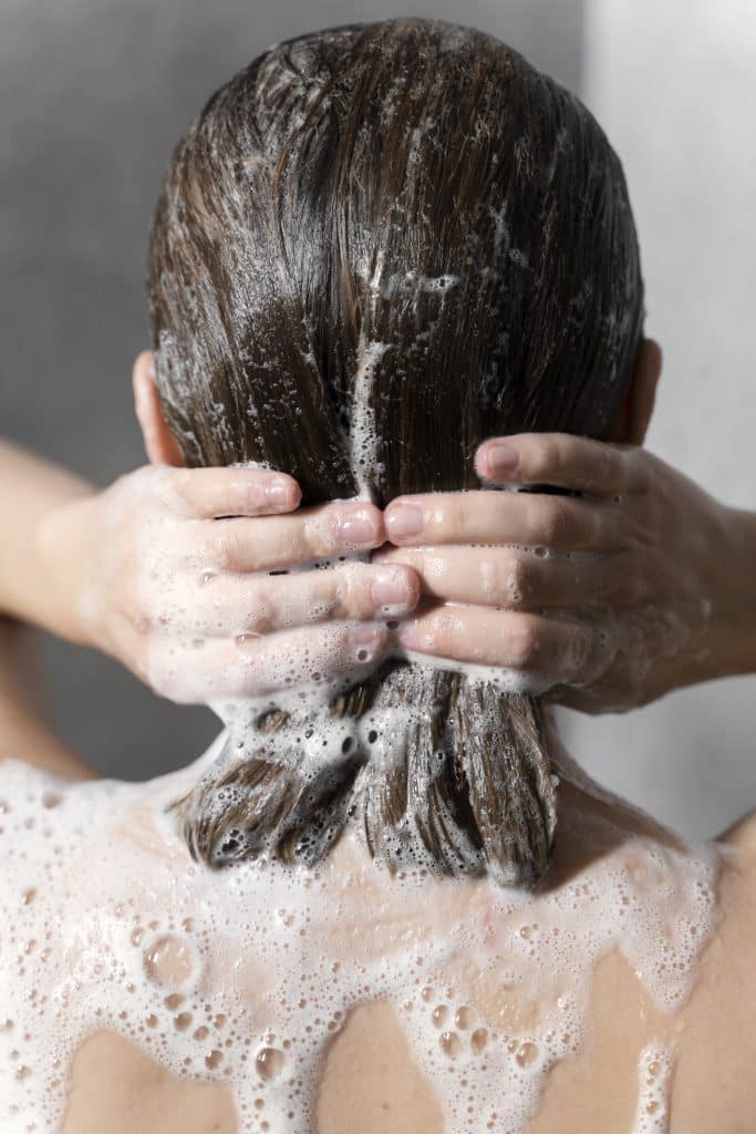 young-woman-applying-anti-dandruff-product (1)