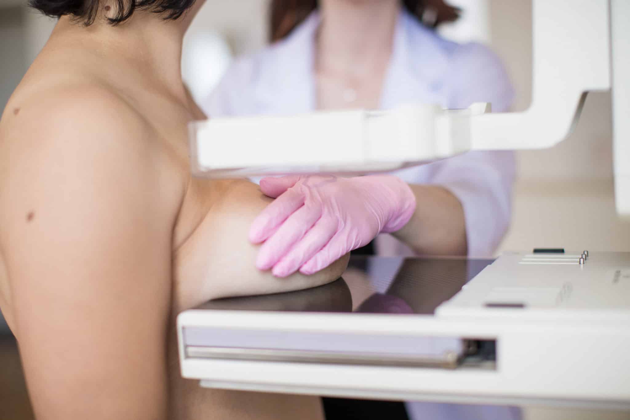 Close-up carrying out the ultrasound examination of the breast of a patient indoors